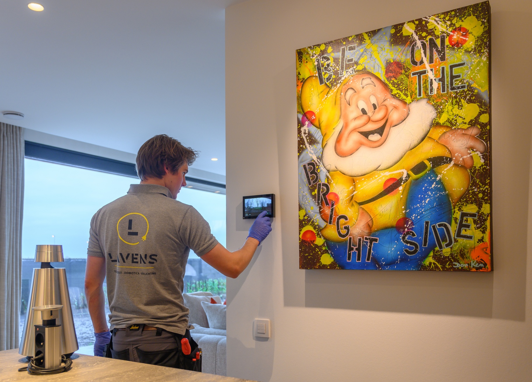 Lavens technieker bedient domotica touchpaneel in moderne woning